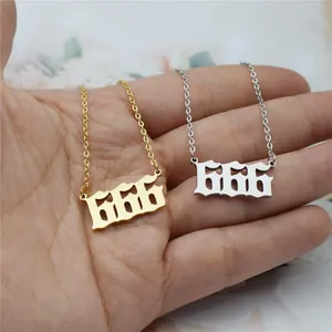 Detail of gold and silver stainless steel angel number 666 necklaces on palm.