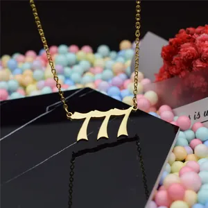 Detailed macro view of a 777 gold angel number pendant necklace on black stand