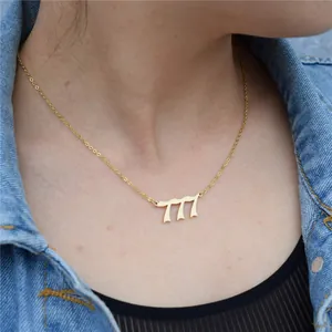 Detailed view of a gold-plated 777 angel number necklace worn by a model in denim.