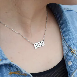 Close-up detail of silver 888 angel number necklace in gothic font worn by model