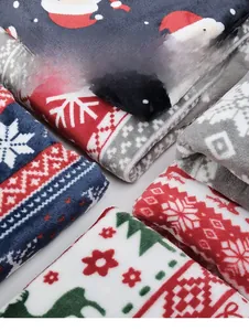 Détail de tissu en flanelle douce à imprimé de Noël avec le Père Noël et des rennes