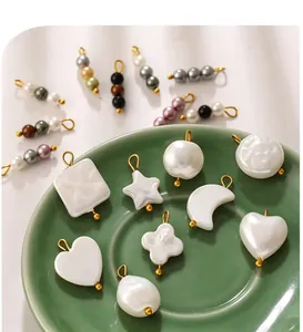 Close-up of heart, star, and moon shaped imitation pearl DIY jewelry charms on a plate