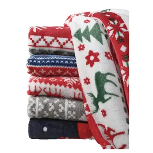 Stack of festive Christmas print flannel fleece blankets with reindeer and tree patterns