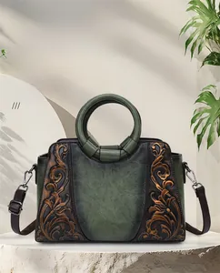 Elegant vintage green embossed leather handbag with floral patterns and circular handle