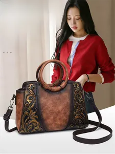 Vintage brown embossed leather handbag with round top handles and shoulder strap