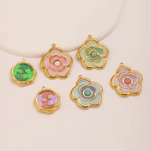 Detalle macro de varios colgantes de camelia de esmalte de colores para bisutería DIY