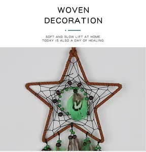 Close-up detail view of a star-shaped dream catcher with vibrant green feathers for wall decor