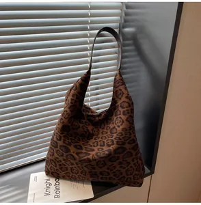 Dettaglio borsa tote in pelle scamosciata leopardata in un ambiente caldo e accogliente.