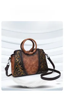 Detailed view of a retro embossed floral handbag with round top handles and strap.