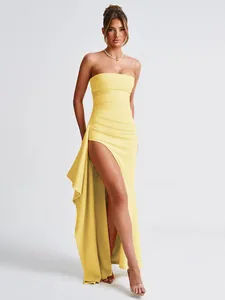 Full view of a yellow strapless dress with high side slit and asymmetrical drape.