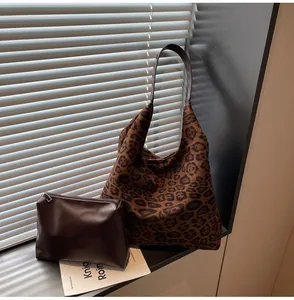 Borsa tote in pelle scamosciata maculata con astuccio marrone sul davanzale.