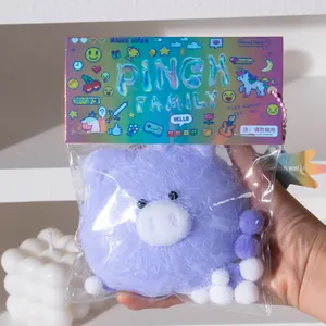 Close-up of a fuzzy purple pig squishy toy in its original Pinch Family packaging