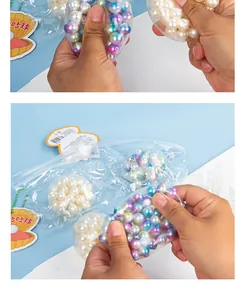 Close-up detail of hand squeezing a colorful iridescent pearl stress relief toy in clear bag