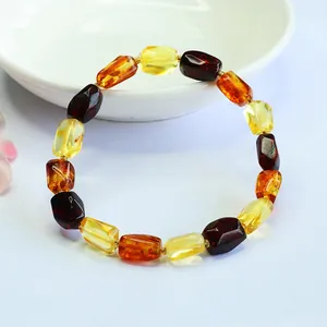 Close-up of a natural multi-color amber bead bracelet with tumbled irregular stones.