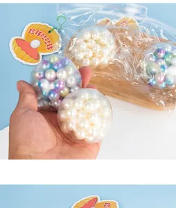 Close-up of transparent decompression balls filled with colorful pearls held in hand.