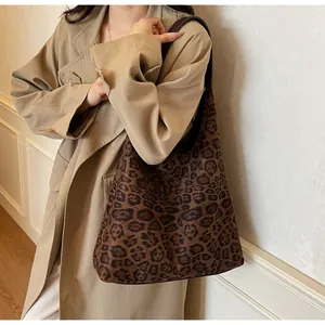 Grande borsa tote in pelle scamosciata con stampa leopardata indossata a spalla da modella