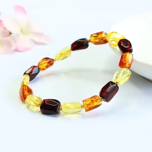 Close-up detail of a natural amber bracelet with gold and blood amber irregular beads.