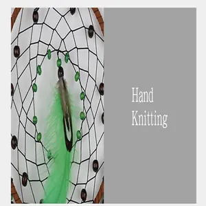 Detailed macro view of handmade dreamcatcher featuring green feathers and black mesh