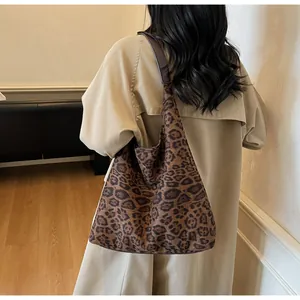 Grande borsa tote scamosciata con stampa leopardata abbinata a un trench beige