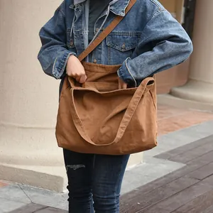 Detailed view of brown canvas shoulder tote bag showing texture and outer pocket.