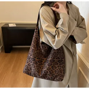 Dettaglio borsa shopper in camoscio leopardato con spalla e texture morbida.