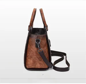 Detailed side view of a vintage brown embossed leather handbag with shoulder strap.