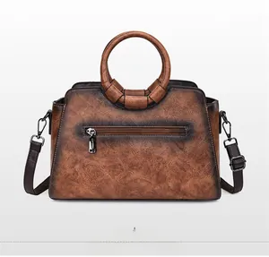 Back view of the vintage embossed brown leather handbag featuring a circular handle