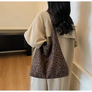 Elegante borsa tote in pelle scamosciata leopardata indossata da una modella.