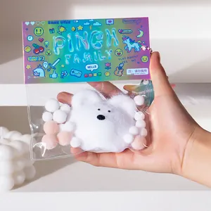 Close-up of a hand holding a cute white plush bear pinch family decompression squishy toy