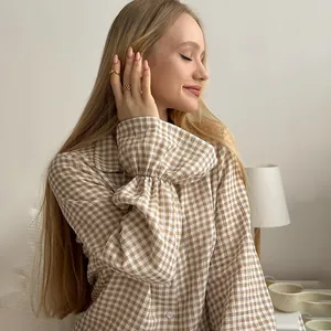 Women's beige gingham cotton pajama set with ruffled sleeves in a cozy home setting