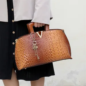 Fashionable brown crocodile pattern tote bag featuring large capacity and a gold V-logo accent.
