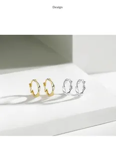 Close-up detail of minimalist 925 sterling silver Möbius twisted hoop earrings in gold and silver