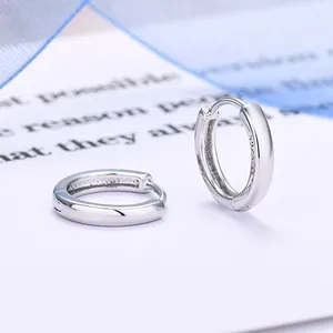 Primo piano di orecchini a cerchio minimalisti in argento sterling 925 lucido.