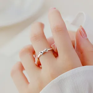 Detailed close-up shot of an elegant S925 sterling silver bow ring on a woman's finger.