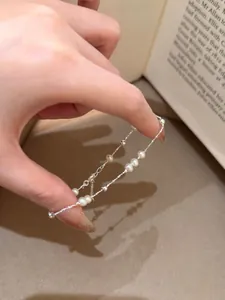 Detail shot of a delicate S925 silver bracelet featuring natural freshwater pearls