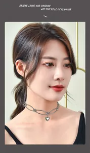 Detailed view of a minimalist metal heart pendant choker necklace on a female model