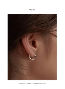 Detailed view of minimalist 925 silver Mobius hoop earrings with a mirror polished finish
