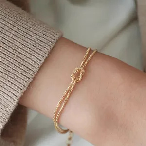 Minimalist S925 sterling silver gold knot bracelet for women displayed on a graceful wrist