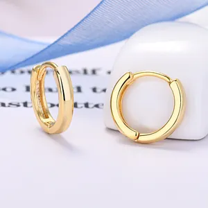Dettaglio ravvicinato di orecchini a cerchio largo placcati in oro con perno in argento 925