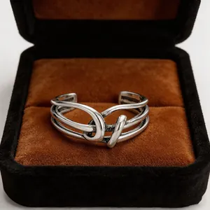 Detail view of a vintage S925 silver knot wrap ring in a brown velvet gift box.