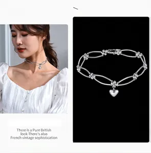 Silver metal heart choker necklace with adjustable chain shown on model and studio.