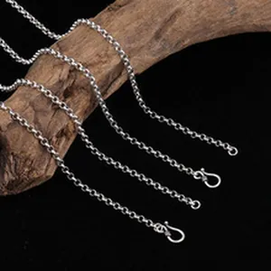 Detailed view of S925 sterling silver vintage style link chains on wood texture.