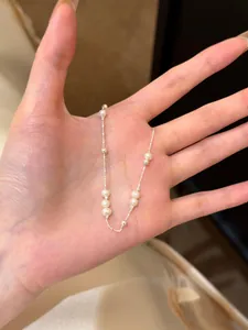 Handheld detail of S925 sterling silver bracelet featuring natural freshwater pearls.
