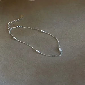 Dettaglio ravvicinato del bracciale in argento 925 con eleganti ciondoli a grana di riso