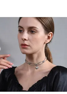Silver-toned minimalist metal choker necklace featuring a delicate heart pendant charm