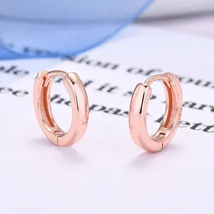 Dettaglio macro di orecchini huggie in argento sterling 925 placcati in oro rosa
