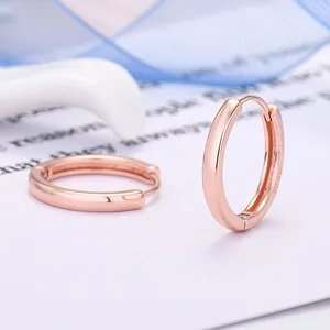 Primo piano di orecchini a cerchio minimalisti in argento 925 placcato oro rosa lucido