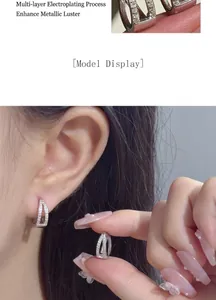 Detailed model wearing S925 silver double V-shaped pavé set small hoop earrings