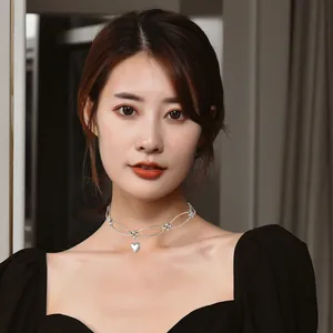 Elegant minimalist silver metal heart pendant choker necklace worn by a model