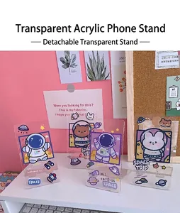 Close-up of cute space-themed transparent acrylic phone stands on a white desk